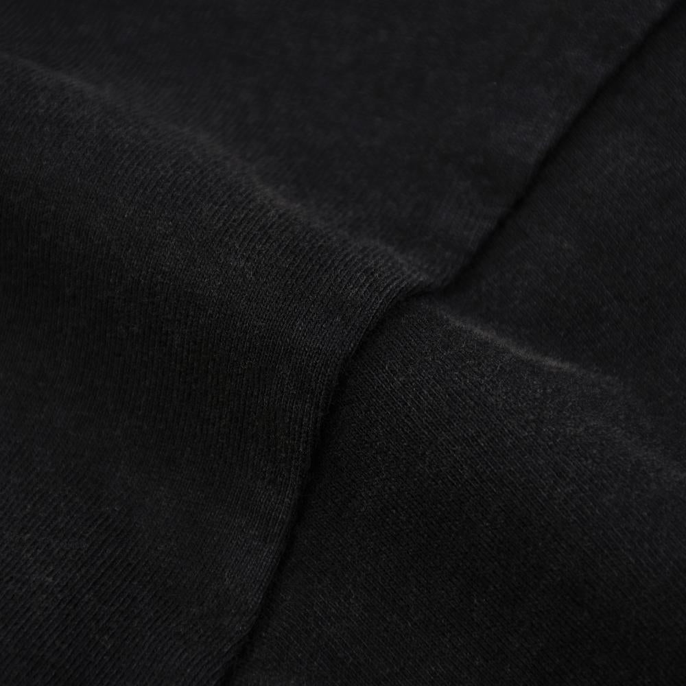 Black enzyme-wash T-shirt sleeve and seam close-up, dense knit surface