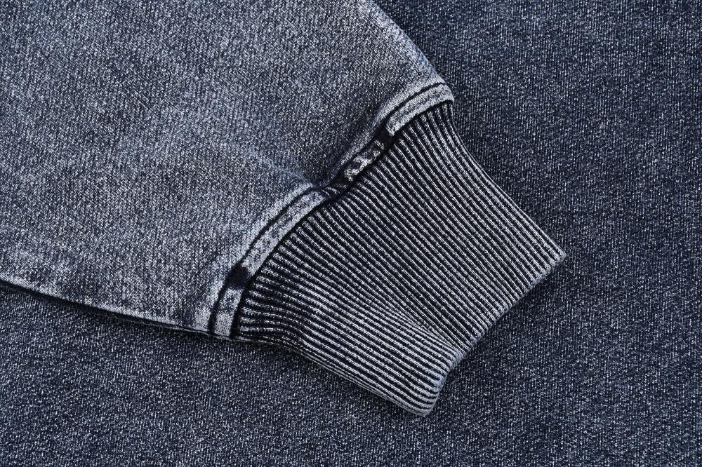 Ribbed cuff and hem stitching detail on acid wash sweatshirt sleeve, blue-gray
