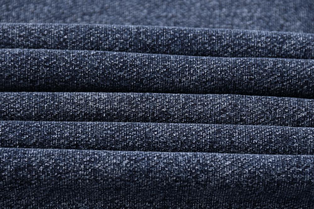 Ribbed waistband detail on acid wash sweatshirt, blue-black texture