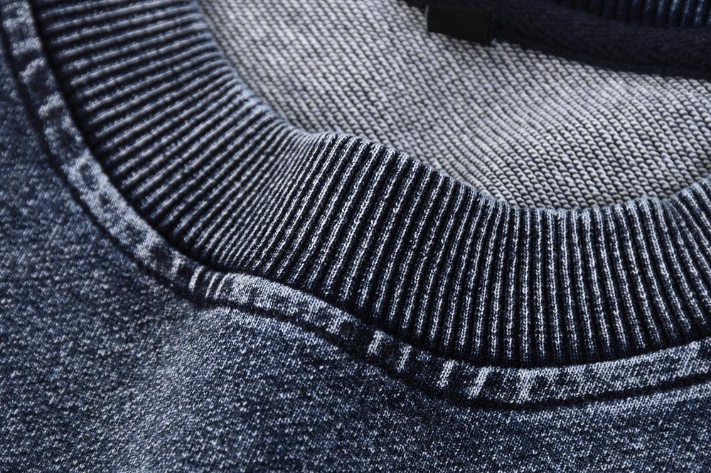 Ribbed crewneck collar with contrast seam stitching on acid wash sweatshirt, blue