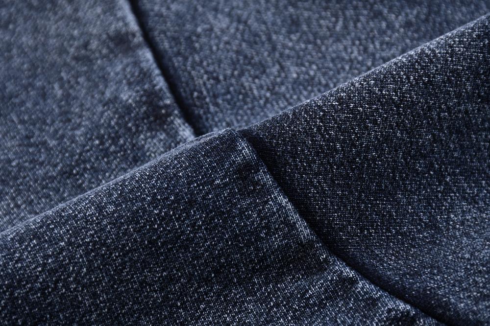 Folded fabric view of acid wash oversized crewneck sweatshirt, dark blue-gray