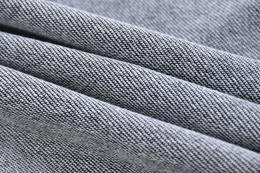 Close-up of smooth acid wash fabric layers on sweatshirt, blue-gray knit