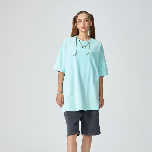 Unisex heavyweight oversized snow-wash T-shirt on model, pale aqua blue