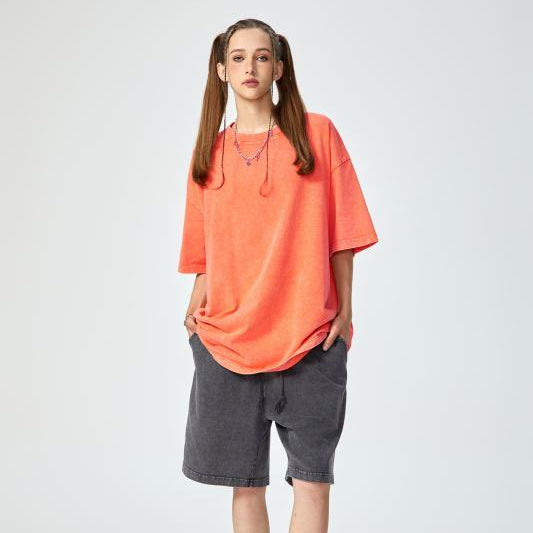 Unisex heavyweight oversized snow-wash T-shirt on model, orange-coral